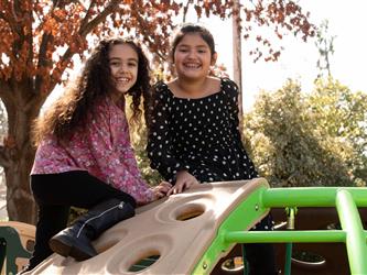 Two students on a climbing structure on the playground
